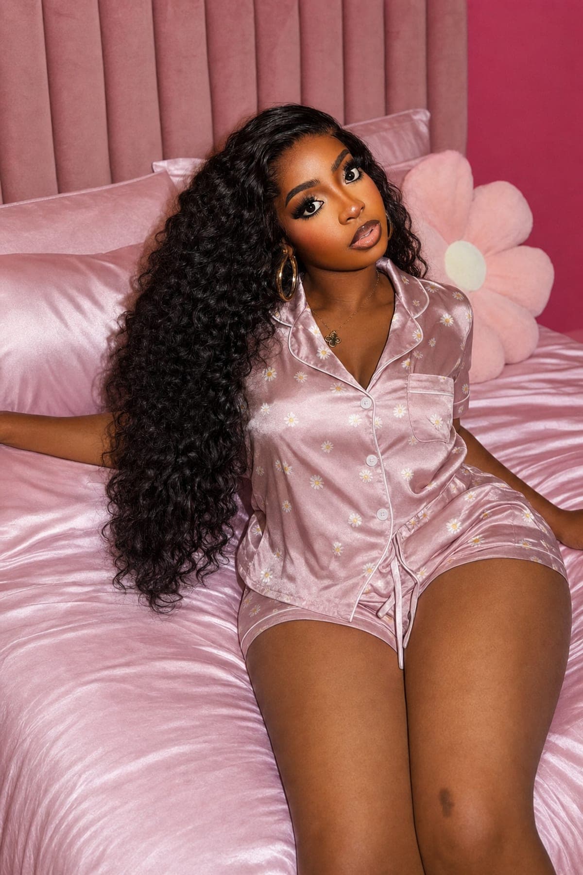 Kamsy on a pink satin bed in the blush daisy-print Miss PJs short set